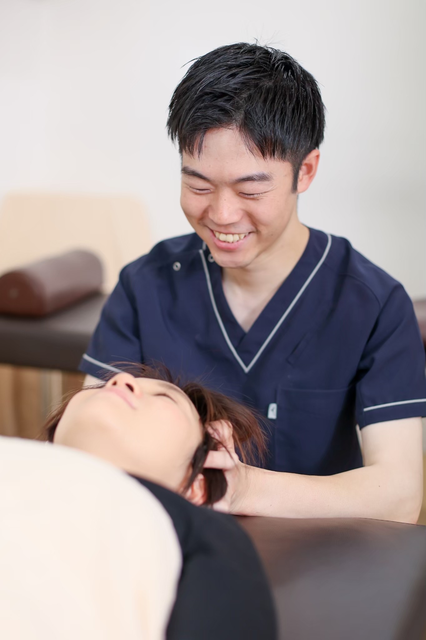 笑顔で施術する柔道整復師・小栗睦大